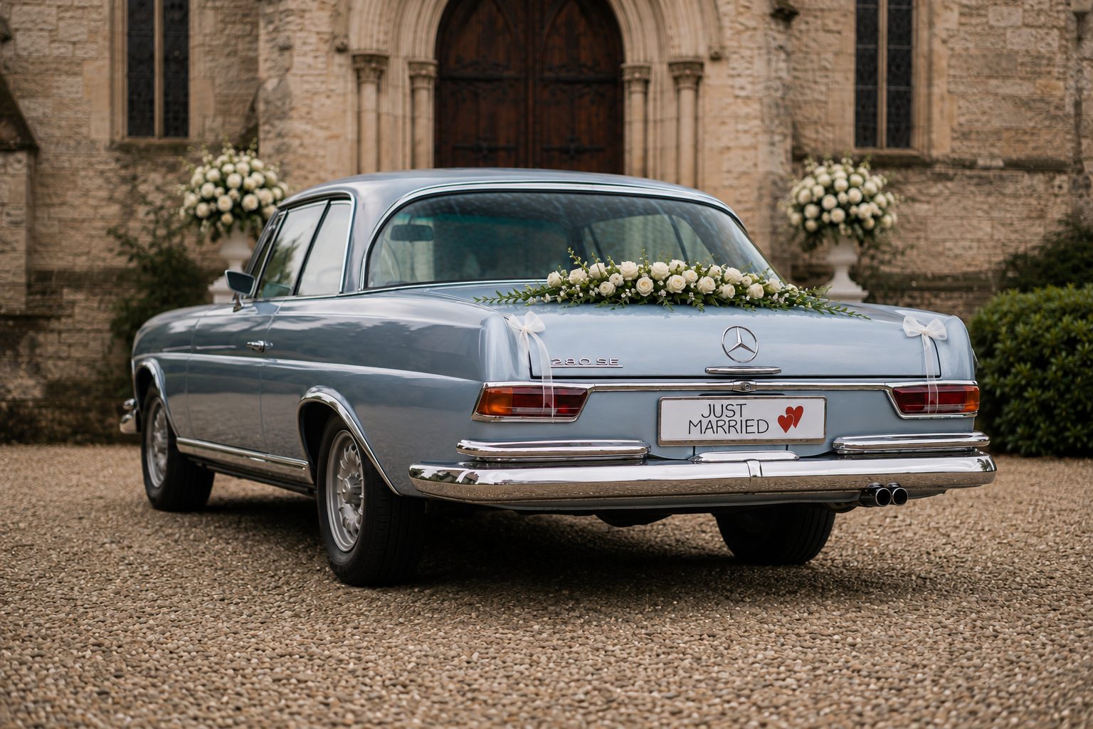 Mercedes Benz S-Klasse Hochzeitsauto von schräg hinten mit Blumenschmuck auf dem Kofferraum